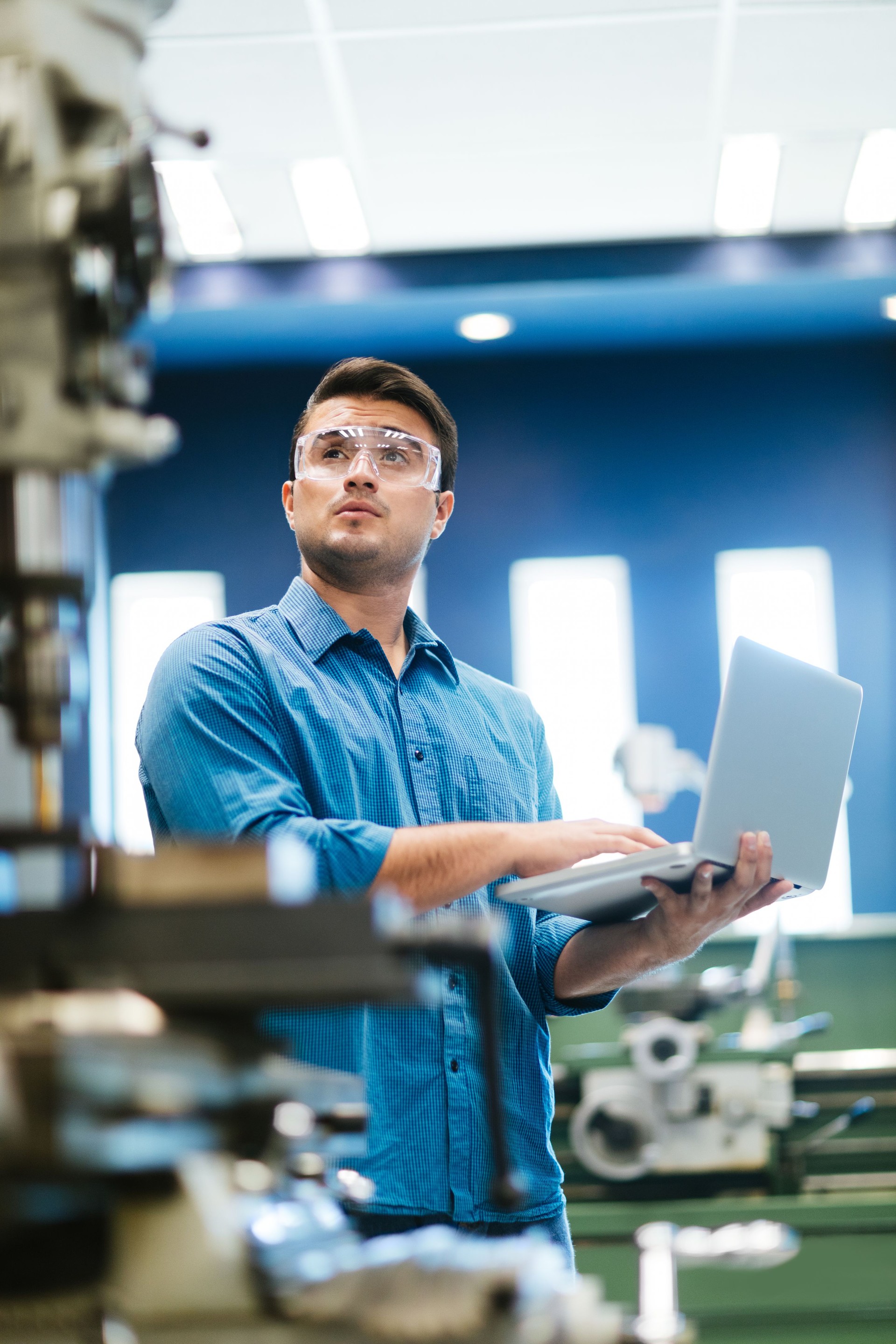 Latin engineer working on laptop and drill